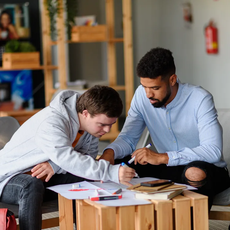 Early years practitioner supporting children at a table